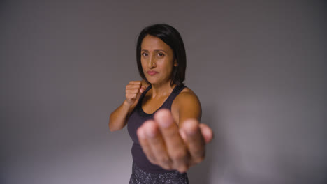 Studio-Portrait-Of-Mature-Woman-Wearing-Gym-Fitness-Clothing-Exercising-Sparring-At-Camera-2